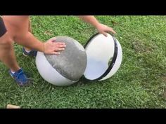 a person is holding onto a large ball in the grass with their hands on it