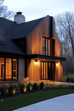 a large house that is lit up at night with lights on the front and side windows