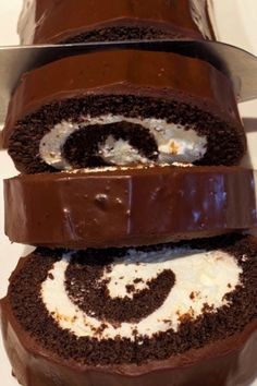 chocolate cake with white frosting and swirls on the top is cut in half