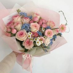 a bouquet of pink and blue flowers in someone's hand