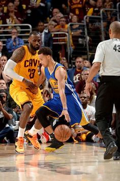 two basketball players in action on the court with people watching from the stands behind them