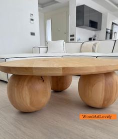 a wooden table sitting on top of a hard wood floor next to a white couch