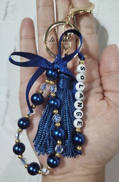 a blue tasseled keychain with the word love on it