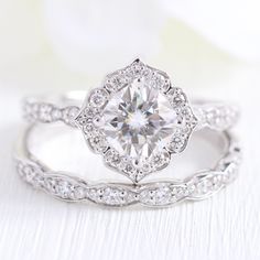 an engagement ring with a diamond center surrounded by diamonds