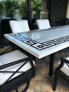 an outdoor table and chairs with white cushions