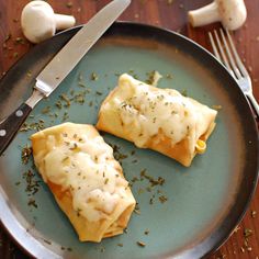 two pieces of food on a plate with a knife and fork next to it,