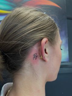 a woman with a small tattoo behind her ear