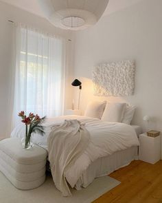 a bedroom with white walls and wooden floors