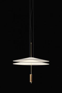 the light fixture is suspended from two brass rods and has three white lamps on each end