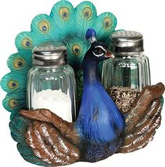 a blue peacock sitting on top of two jars