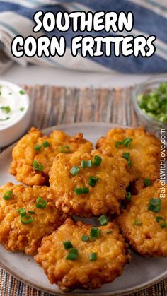 fried corn fritters are served on a plate with green onions and parsley