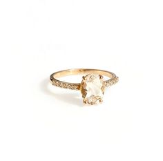 a gold ring with an oval cut diamond and pave set diamonds on the sides