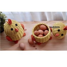 two baskets filled with eggs sitting on top of a wooden table next to an egg holder