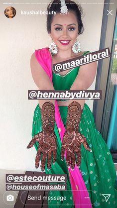 a woman in a green and pink dress with henna on her hands