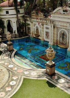 an aerial view of a pool in the middle of a courtyard with statues around it