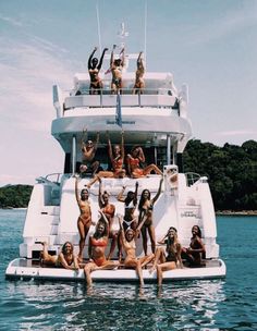 a group of people on a boat in the water with their arms up and legs out