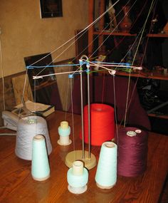 several spools of thread sitting on top of a wooden table