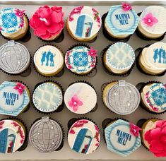 cupcakes decorated with blue and pink frosting in a box