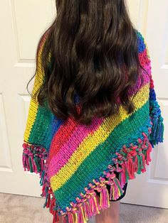 the back of a woman's head wearing a multicolored ponchy