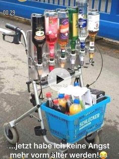 a cart full of bottles and drinks on the side of the road with an ad in front of it