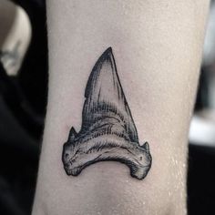 a small black and white hat tattoo on the leg