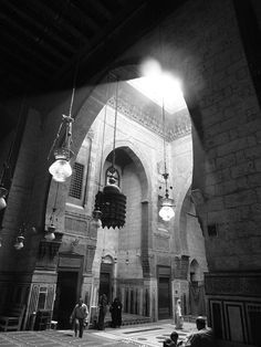 the inside of a large building with several lights hanging from it's ceiling