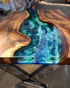 a table made out of wood and glass with water running down it's sides