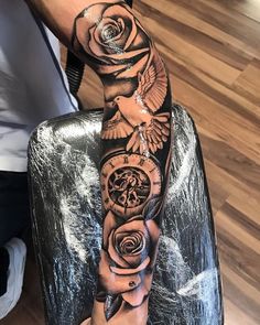 a man's arm with a clock and roses on it