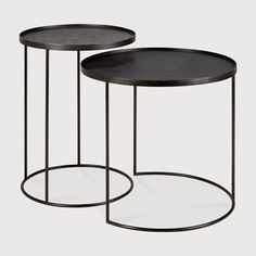 two round tables with metal bases and black wood tops, one on each end table