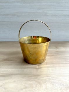 a metal bucket sitting on top of a wooden table