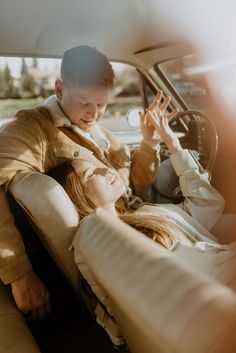 a man and woman sitting in the back seat of a car