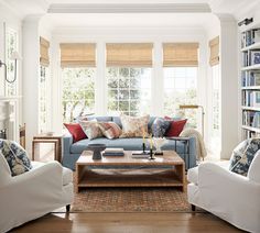 a living room filled with furniture and lots of books on the shelves in front of them