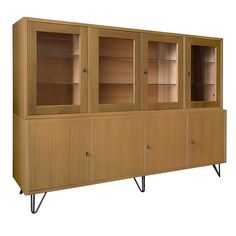 a wooden cabinet with glass doors and metal legs