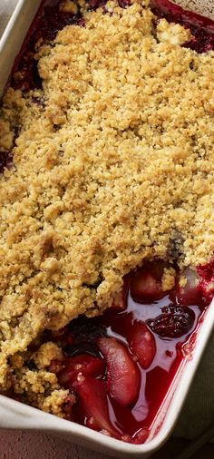 a close up of a casserole dish with strawberries and crumbs