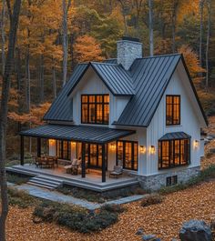 a house in the woods with lots of windows and lights on it's roof