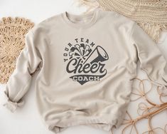 "Personalized Cheer Coach Sweatshirt, Custom Cheer Coach Sweater, Custom Team Name, Mascot Tee, Gameday Vibes, Cheerleader Shirt,Cheerleadingt How to Order T-shirt  1-        Please, check and review all photos 2-        Please choose your t-shirt style and size 3-        Please choose your t-shirt color 4-        Click add to cart. 5-        Please click the \"Proceed to Check Out\" button. Important Notice 1- We have multi brand shirts. Your order may contain different brand of t-shirts. If yo Cheer Coach Sweatshirt, Cheer Coach Outfit, Cheer Shirt Ideas, Coach Sweater, Peewee Cheer, Dtf Shirts, Coach Sweatshirt, Cheer Team Shirts, Cheer Coach Shirts