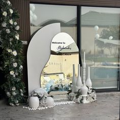 a welcome sign and vases in front of a building