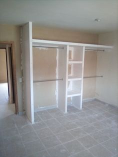 an empty room with white shelves and tile flooring in the process of being remodeled