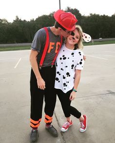 a man and woman in matching outfits pose for a photo on an empty basketball court