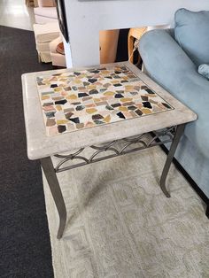 a coffee table sitting on top of a carpeted floor next to a blue couch