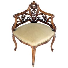 an ornate wooden chair with cream colored upholstered seat and back cushion, viewed from the front