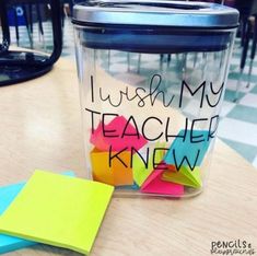 a jar that has some sticky notes in it and is sitting on a table next to a pair of scissors