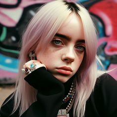 a woman with pink hair and piercings poses in front of graffiti