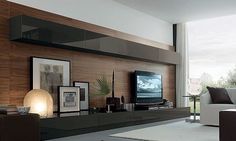 a living room filled with furniture and a flat screen tv on top of a wooden wall