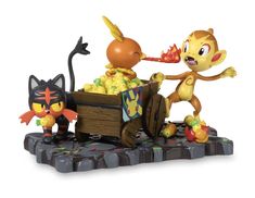 a figurine of two cats and a cat in a cart with food on it