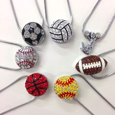 a bunch of necklaces that have different designs on them and some balls in the middle