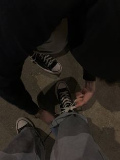 two people standing next to each other on the floor with their feet up in front of them