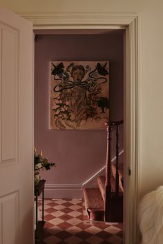 an entry way with a painting on the wall and stairs leading up to another room