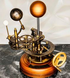 an antique clock with gears and pendulums on a marble surface