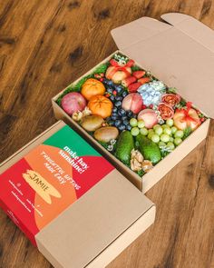 an open box of fruit sitting on top of a wooden table